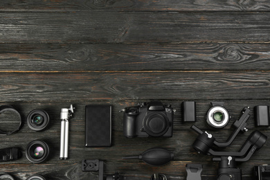 Photo of Flat lay composition with camera and video production equipment on black wooden table. Space for text