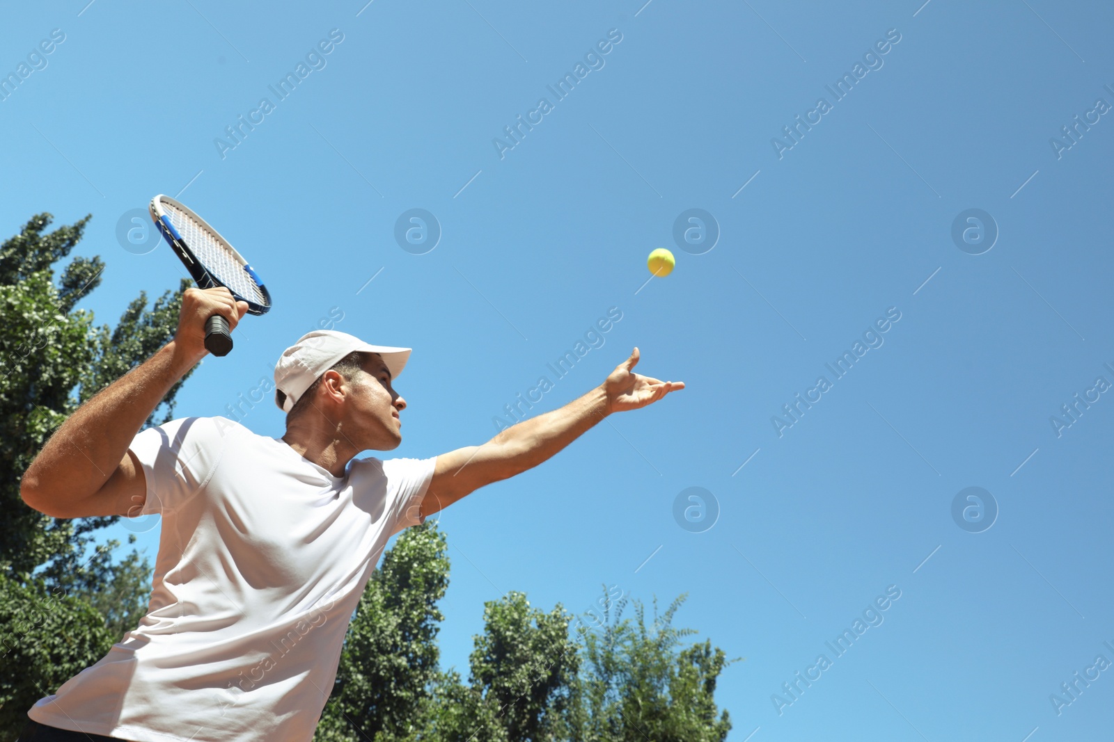 Photo of Man playing tennis on court, low angle view