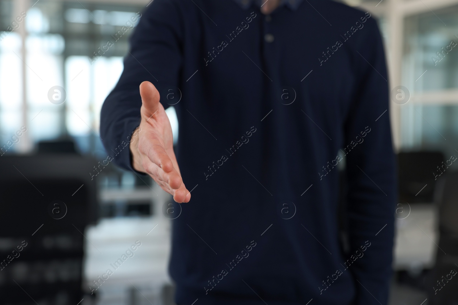 Photo of Man welcoming and offering handshake indoors, closeup