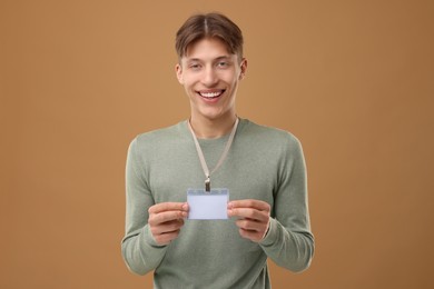 Photo of Happy man with blank badge on light brown background