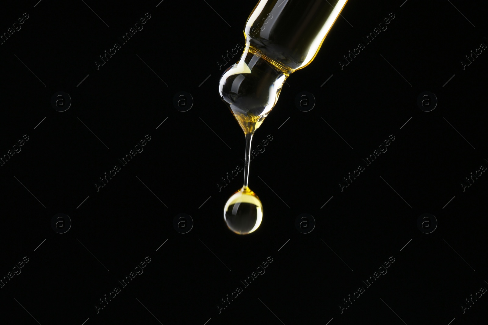 Photo of Dripping tincture from pipette on black background, closeup. Space for text