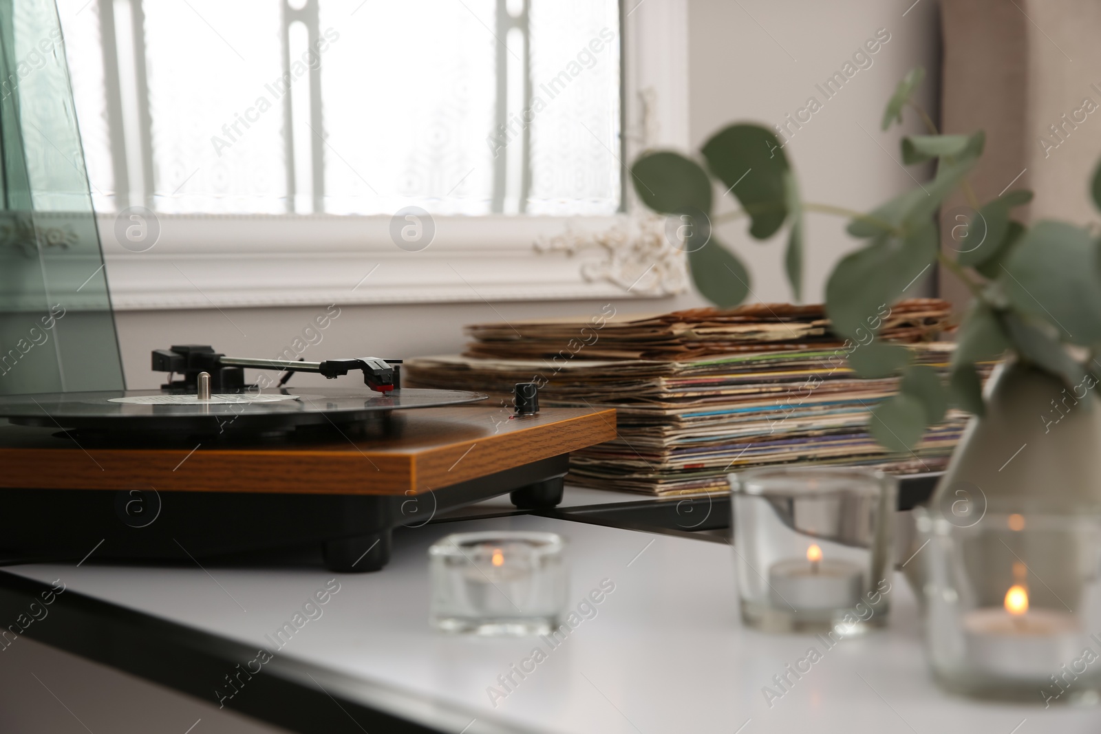 Photo of Stylish turntable with vinyl record on table indoors