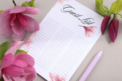 Photo of Guest list, pen and beautiful flowers on grey background, flat lay. Space for text