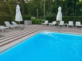 Photo of Outdoor swimming pool in luxury hotel on sunny summer day. Time for relax