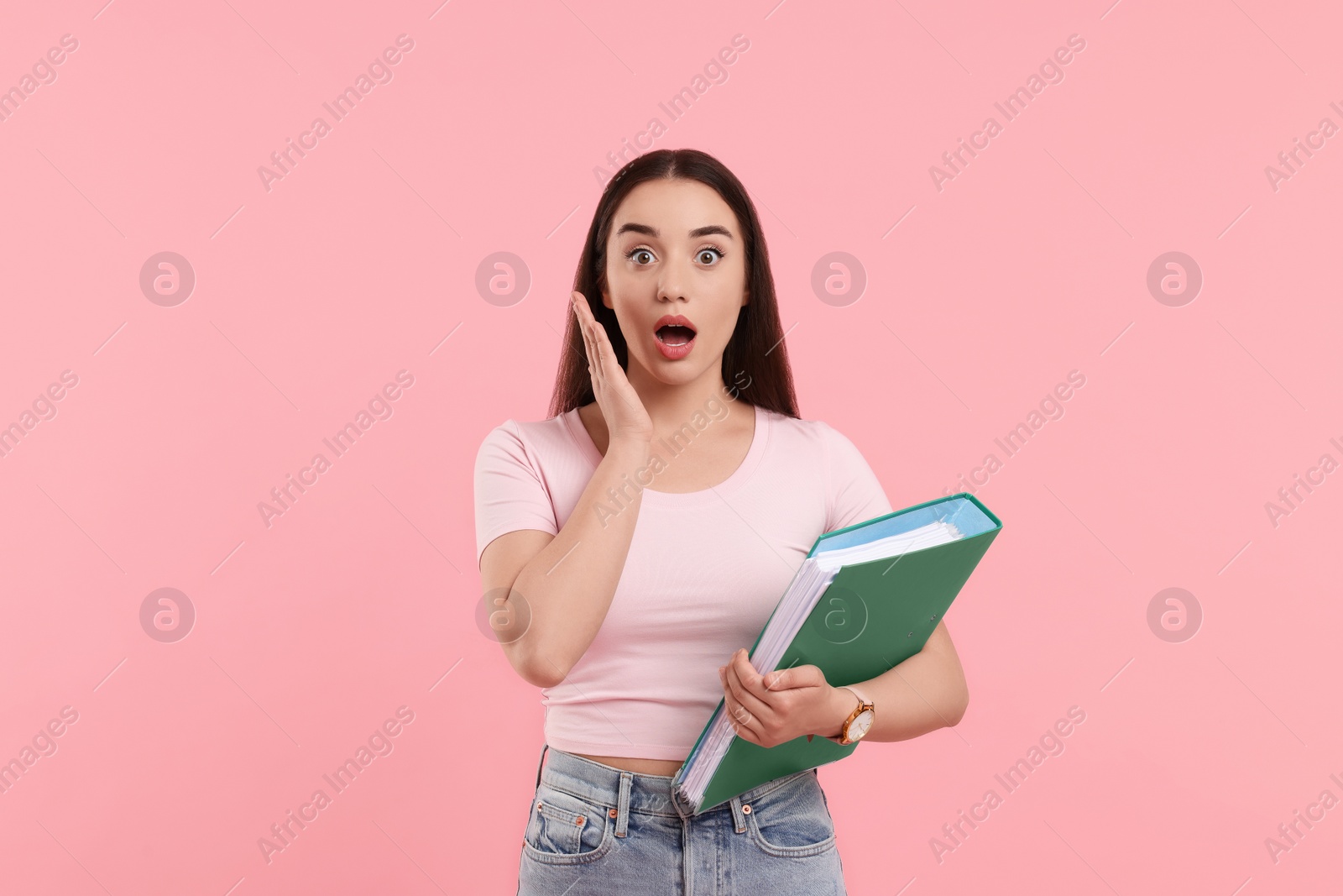 Photo of Surprised woman with folder on pink background