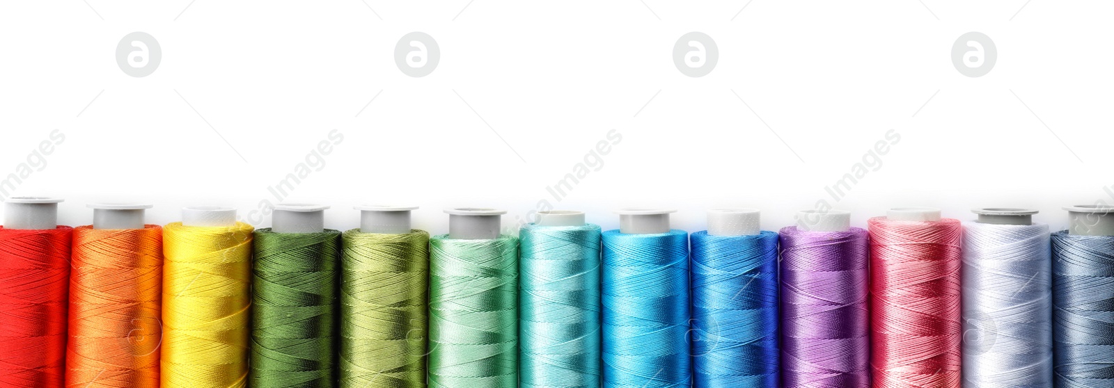 Photo of Color sewing threads on white background, top view