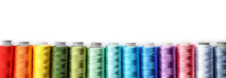 Photo of Color sewing threads on white background, top view