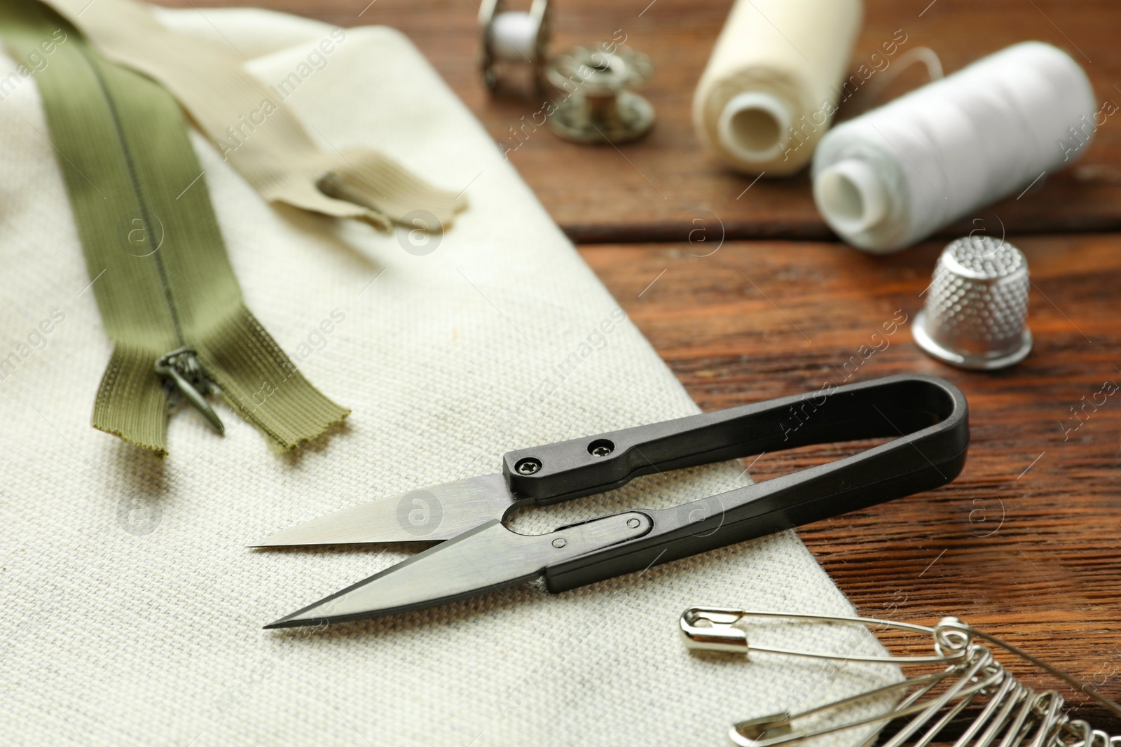 Photo of Threads and other sewing supplies on wooden table