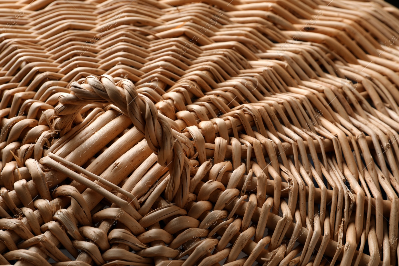 Photo of Lid of handmade wicker basket as background, closeup