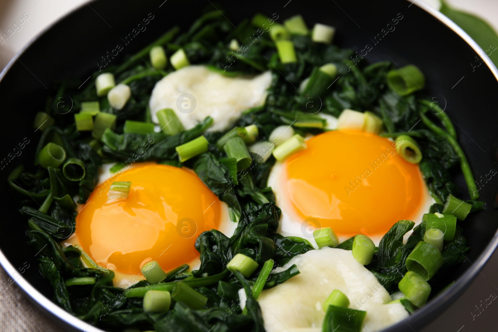 Photo of Tasty green Shakshouka in frying pan, closeup