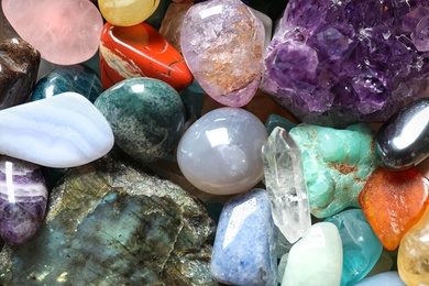 Different beautiful gemstones as background, top view