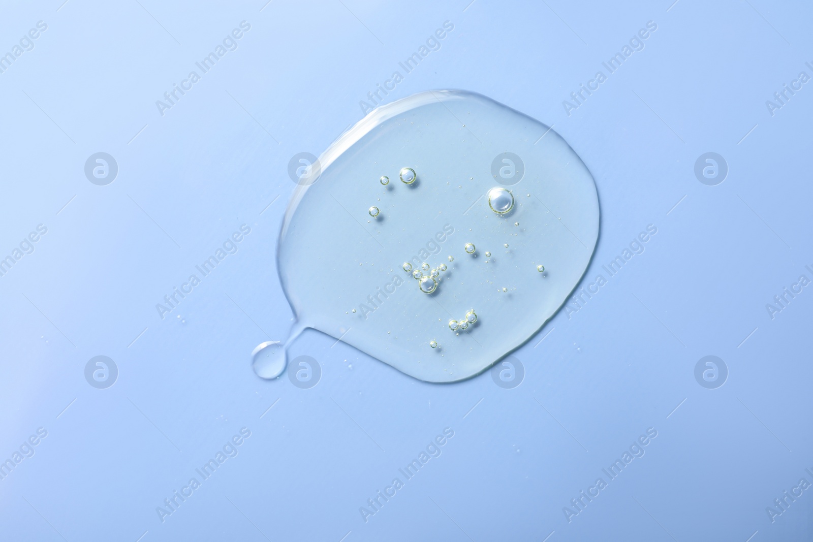 Photo of Drop of hydrophilic oil on light blue background, top view