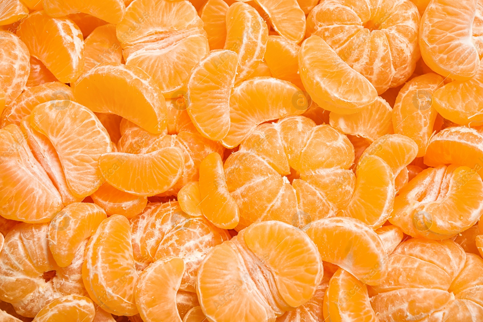 Photo of Fresh juicy tangerine segments as background, top view