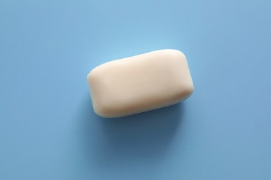 Soap bar on light blue background, top view