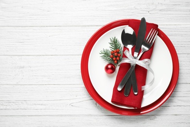 Photo of Christmas table setting on white wooden background, top view. Space for text