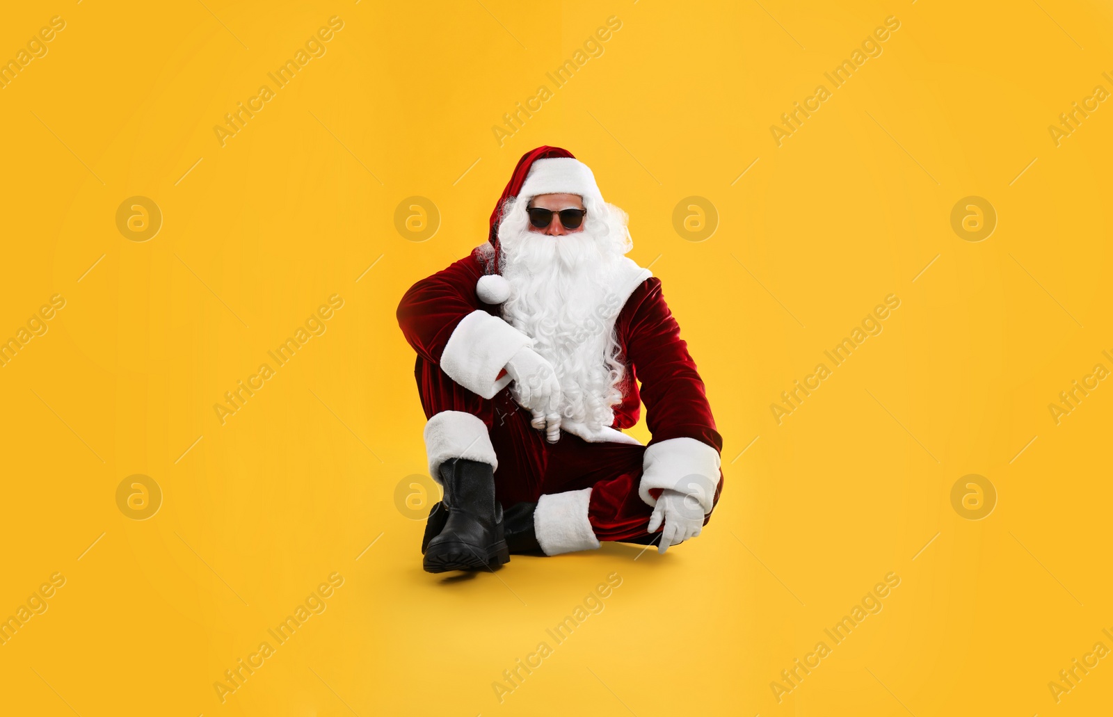 Photo of Santa Claus with sunglasses on yellow background