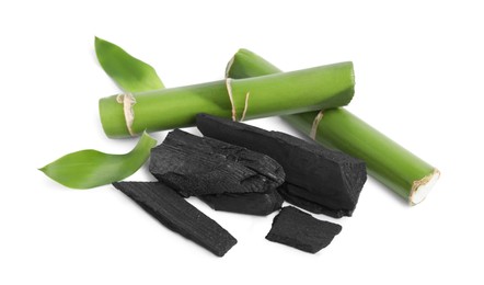 Photo of Fresh bamboo and charcoal on white background