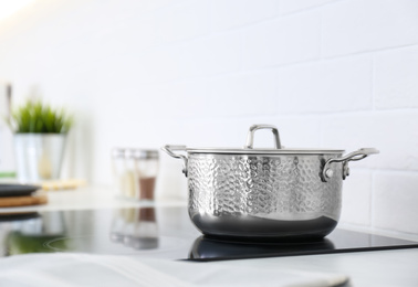 New shiny saucepan on stove in kitchen