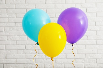 Photo of Bright balloons near brick wall. Celebration time