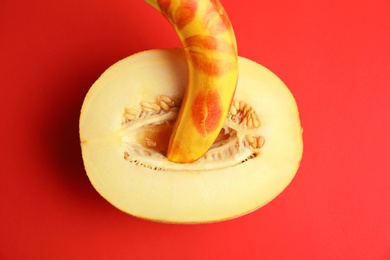 Flat lay composition with fresh banana and melon on red background. Sex concept