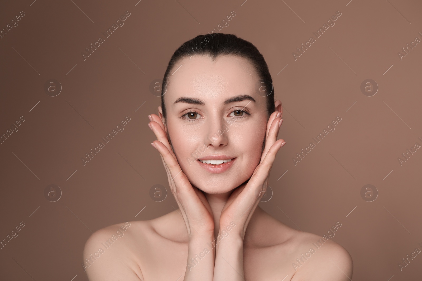 Photo of Portrait of beautiful young woman on brown background