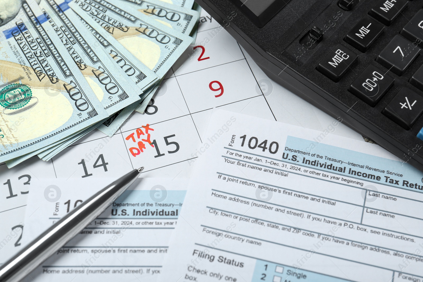 Photo of Tax day. Calendar with date reminder, documents, dollar banknotes, pen and calculator on table