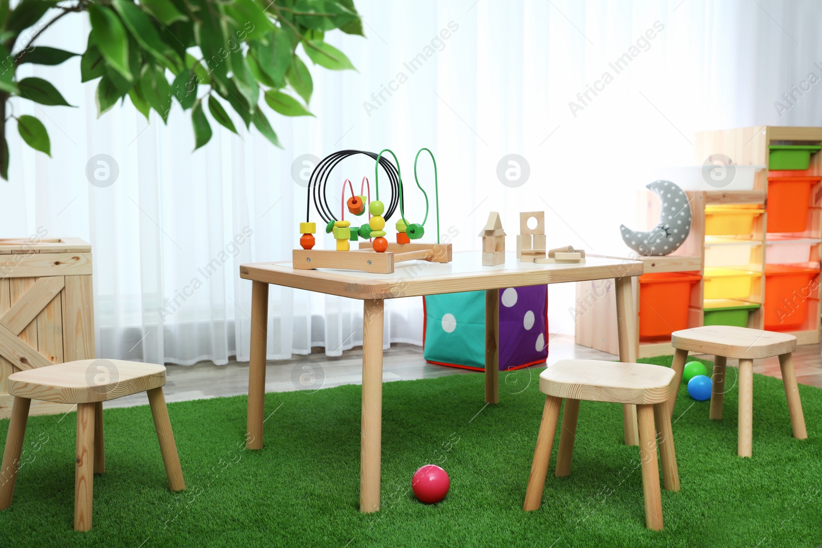 Photo of Stylish playroom interior with toys and modern wooden furniture