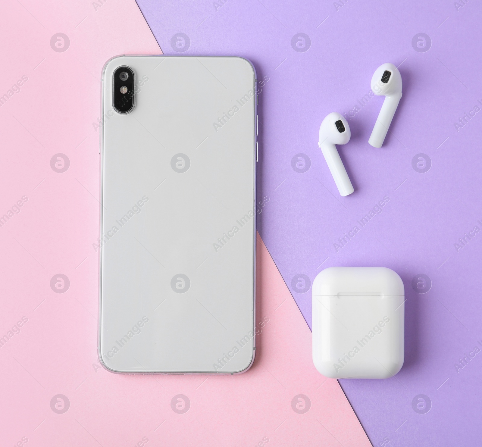 Photo of Wireless earphones, mobile phone and charging case on color background, flat lay