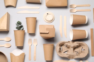 Flat lay composition with eco friendly food packagings and eucalyptus leaves on light grey background