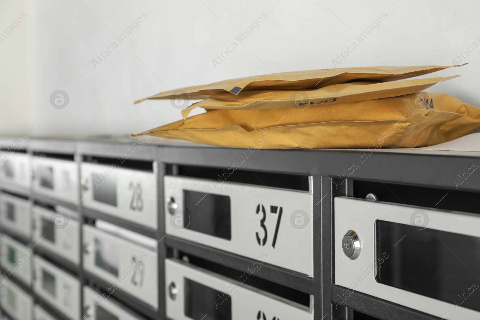 Photo of New mailboxes with keyholes, numbers, receipts and envelopes in post office, closeup