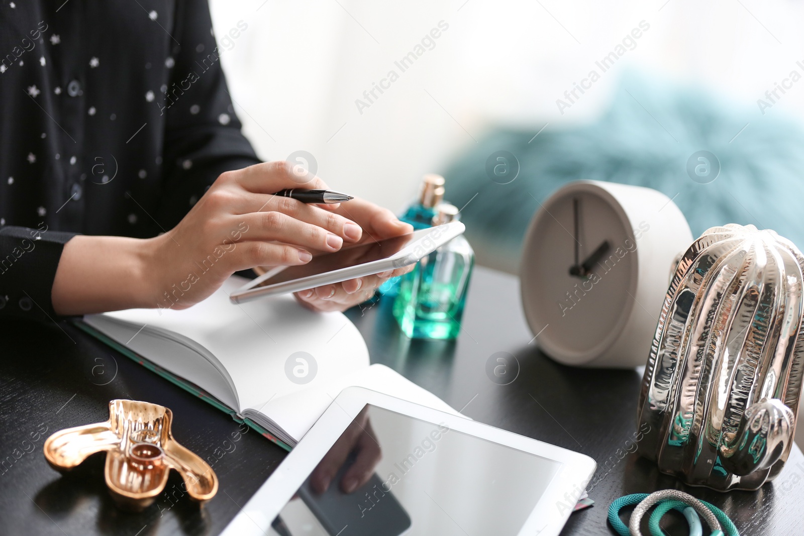 Photo of Female blogger using smartphone at table indoors, closeup