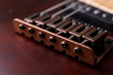 Photo of Closeup view of electric guitar, focus on bridge with strings