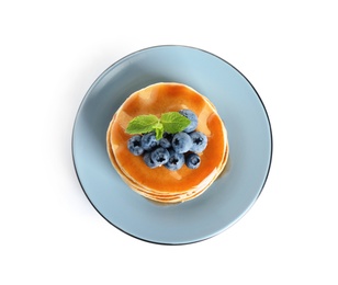 Plate of delicious pancakes with fresh blueberries and syrup on white background, top view