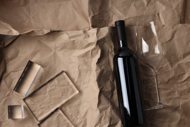 Photo of Stylish presentation of delicious red wine in bottle and glass on paper background, top view. Space for text
