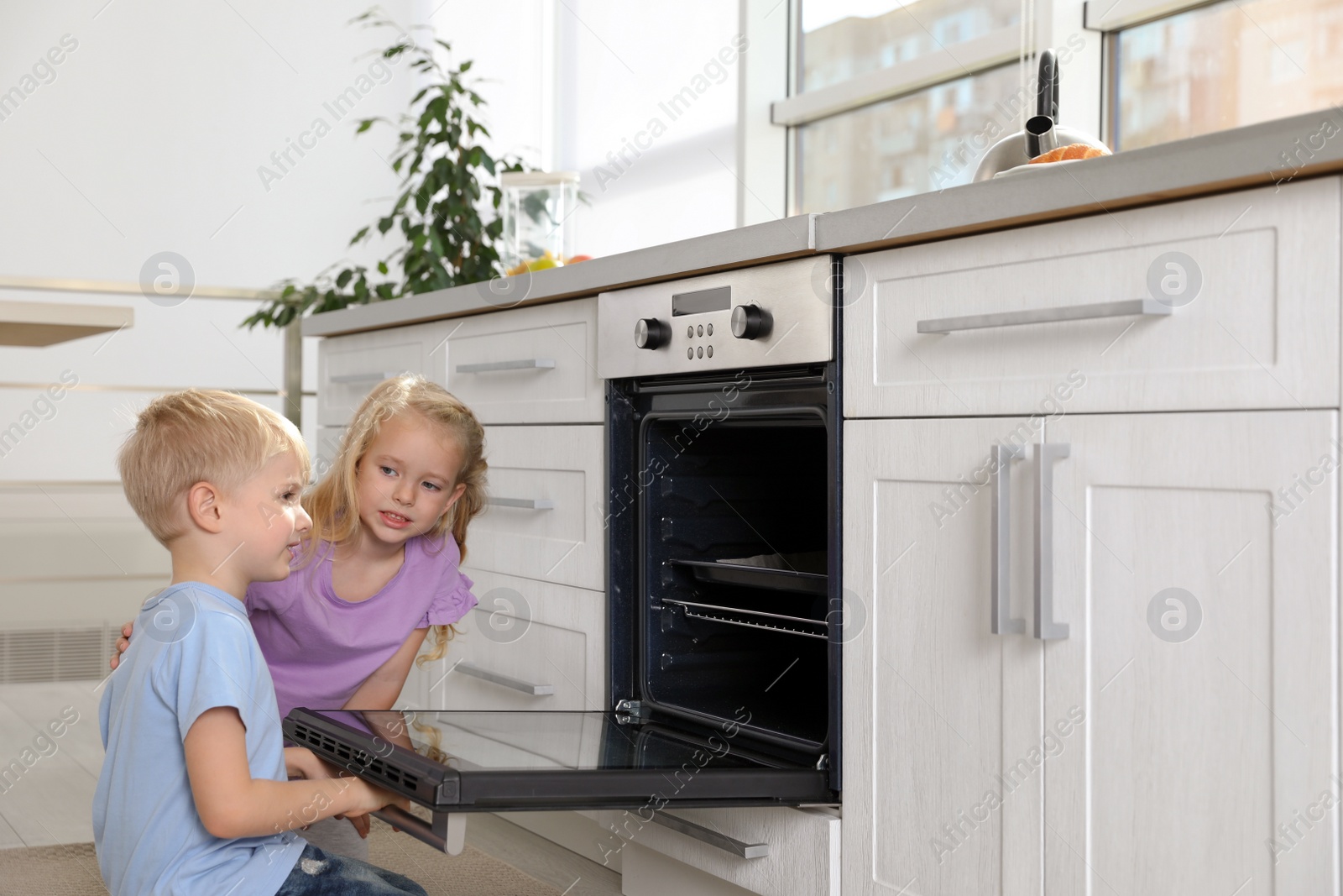 Photo of Little kids baking something in oven at home