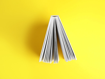 Hardcover book on yellow background, top view