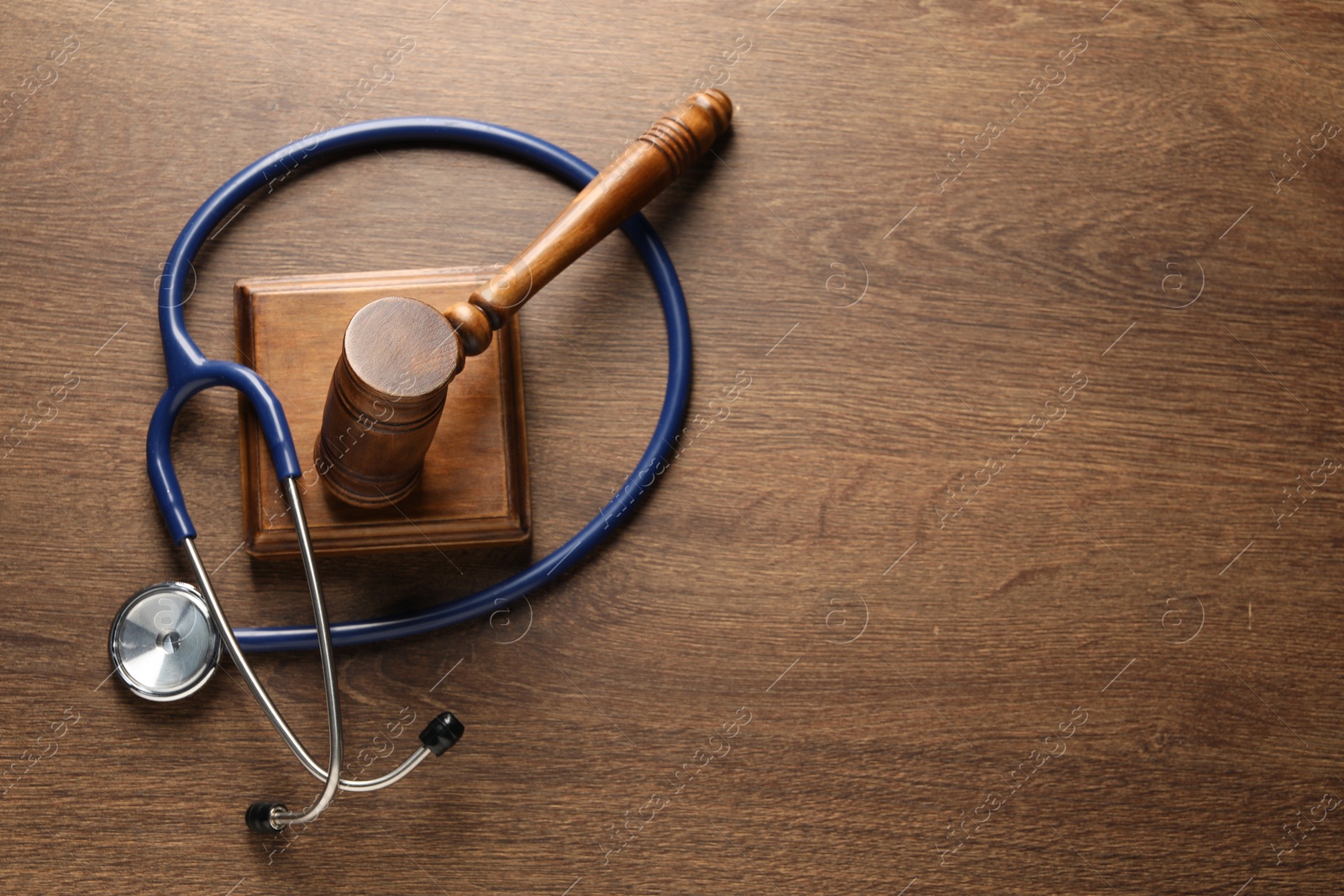 Photo of Law concept. Gavel and stethoscope on wooden table, top view. Space for text