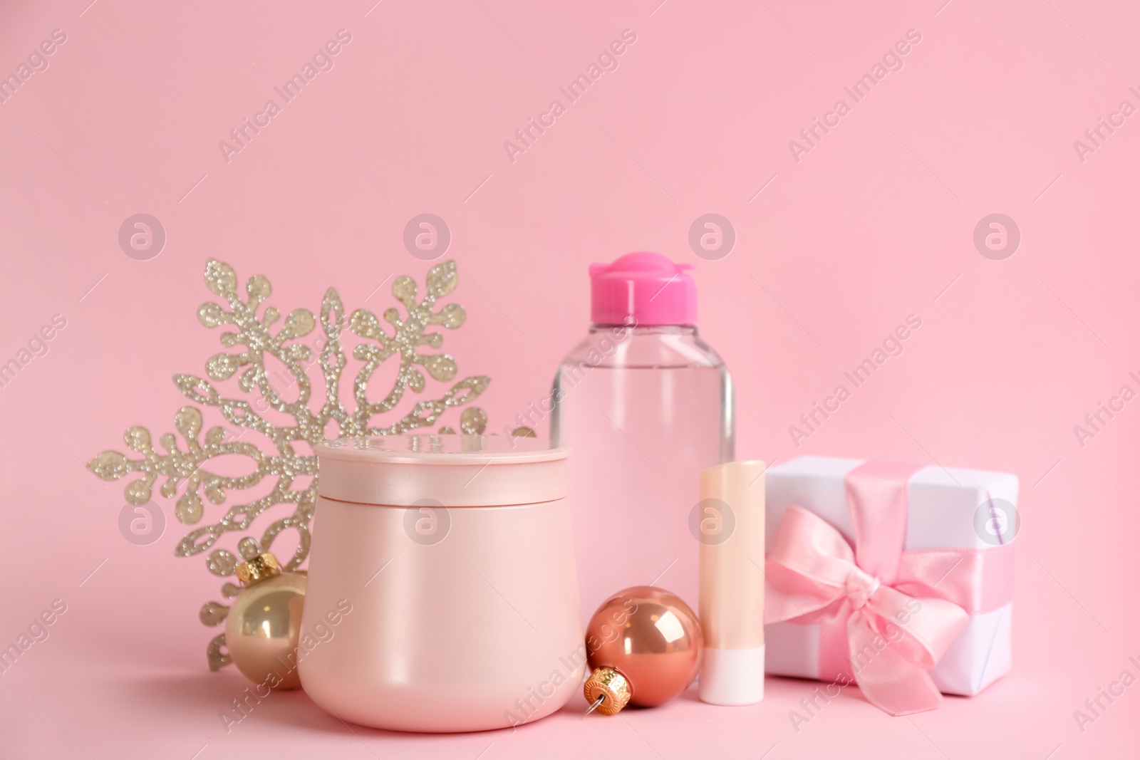 Photo of Beautiful composition with cosmetic products on pink background. Winter care