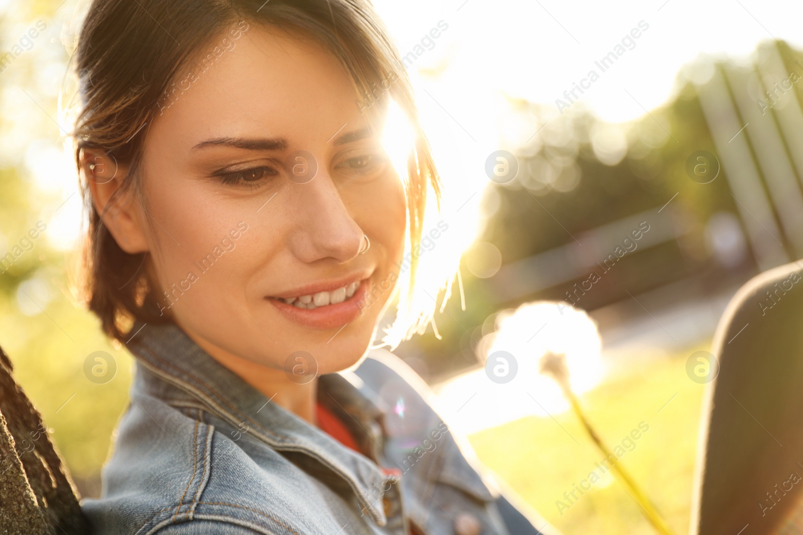 Photo of Young woman with dandelion in park on sunny day. Allergy free concept