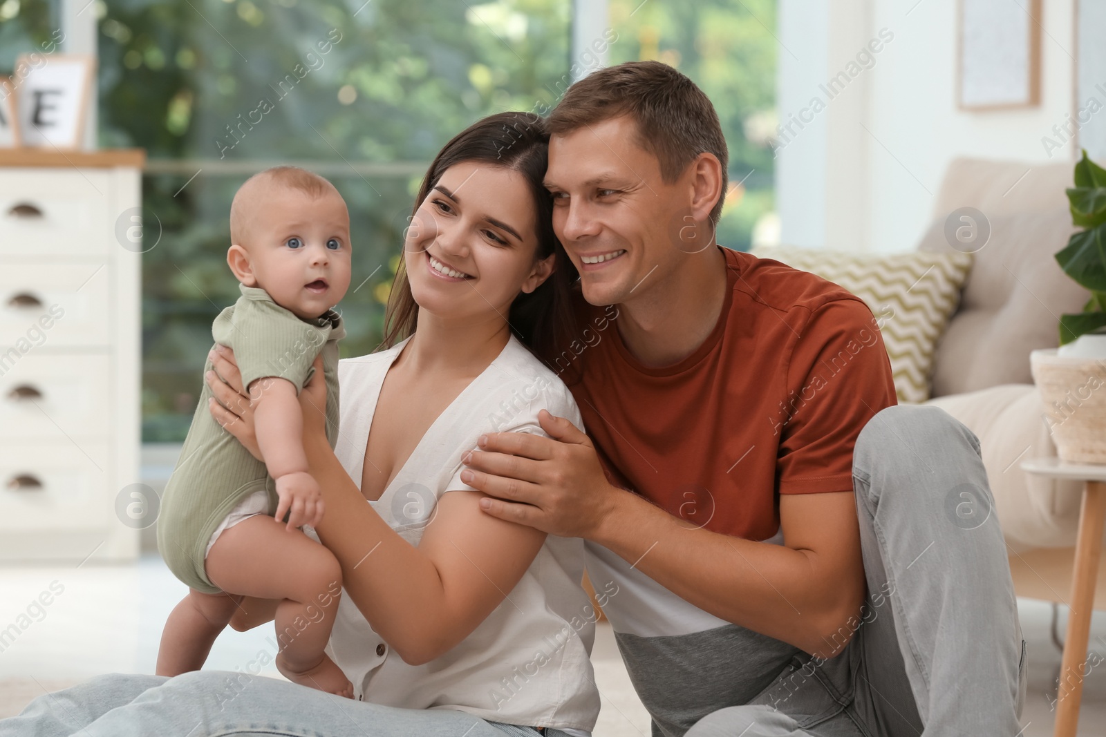 Photo of Portrait of happy family with their cute baby at home