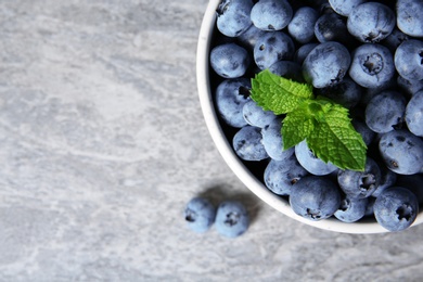 Photo of Crockery with fresh blueberries and space for text on table, top view