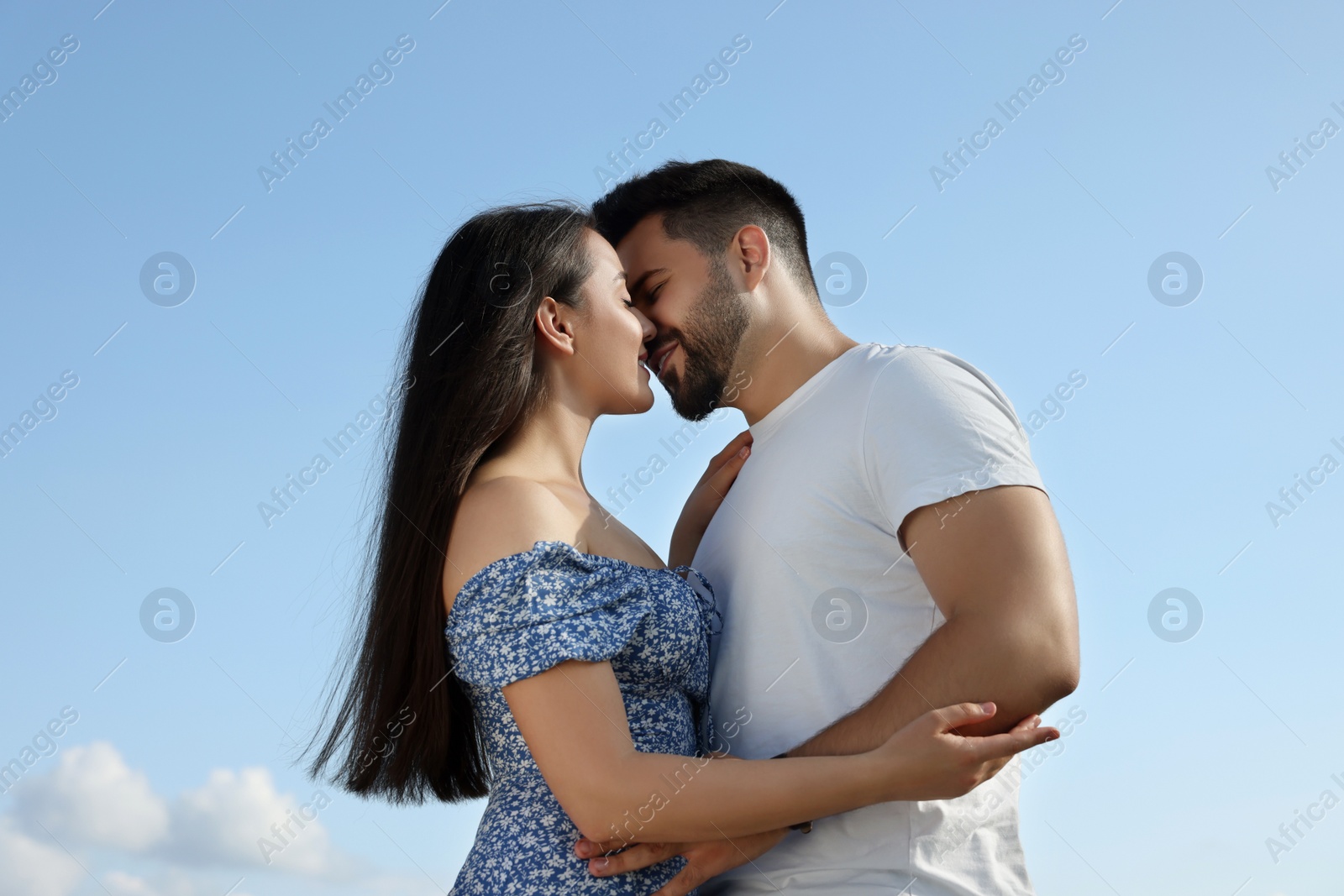 Photo of Romantic date. Beautiful couple spending time together against blue sky