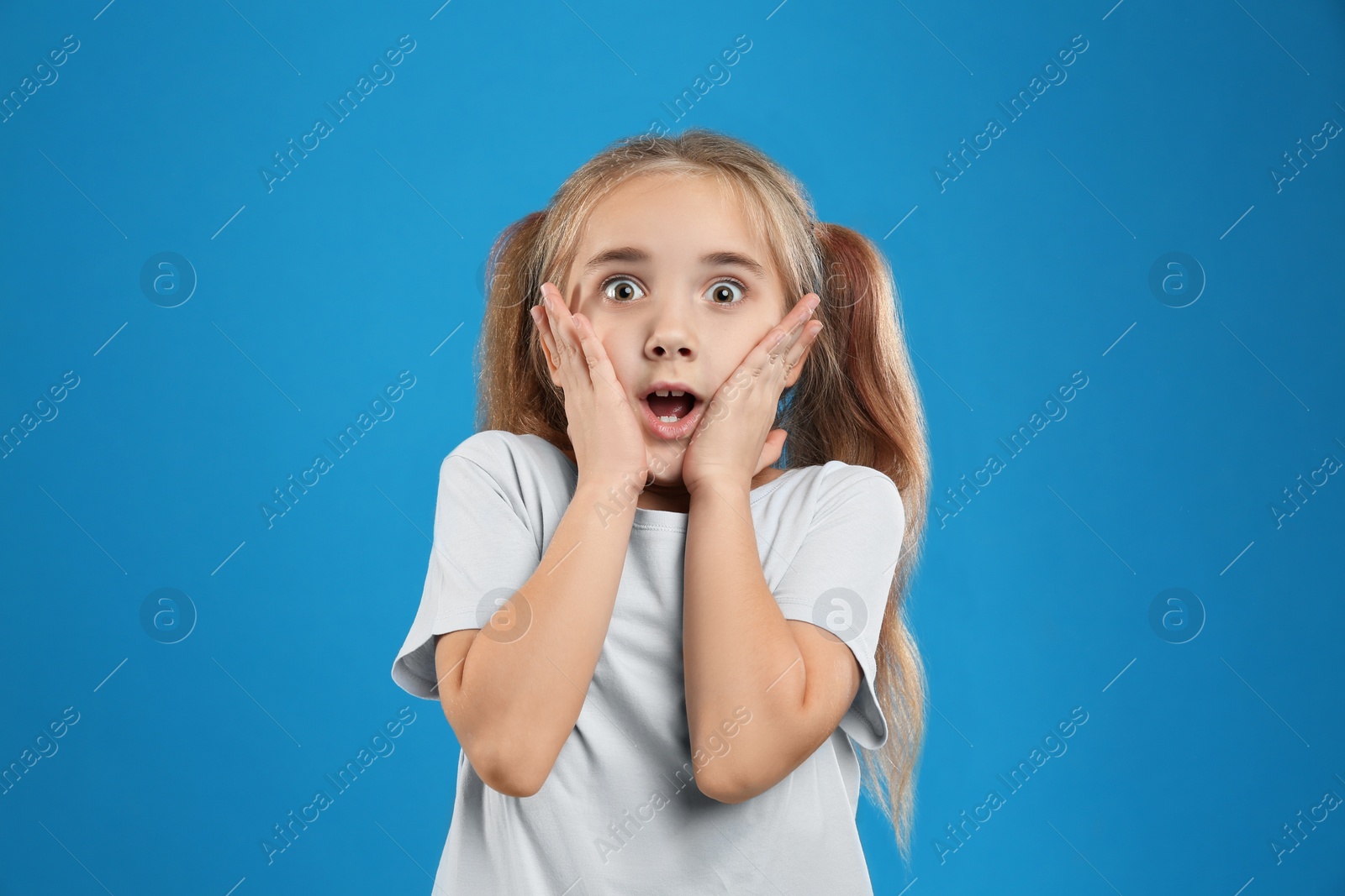 Photo of Cute little girl posing on blue background