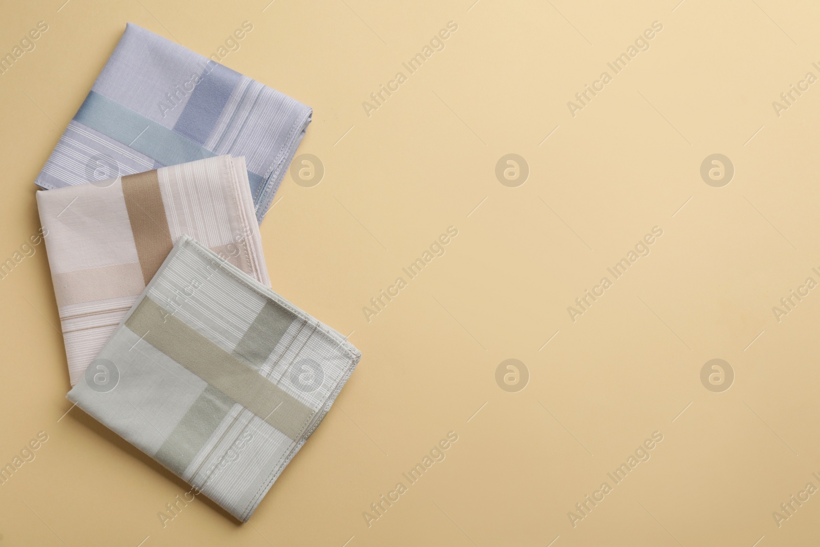 Photo of Stylish handkerchiefs on beige background, flat lay. Space for text