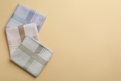 Stylish handkerchiefs on beige background, flat lay. Space for text
