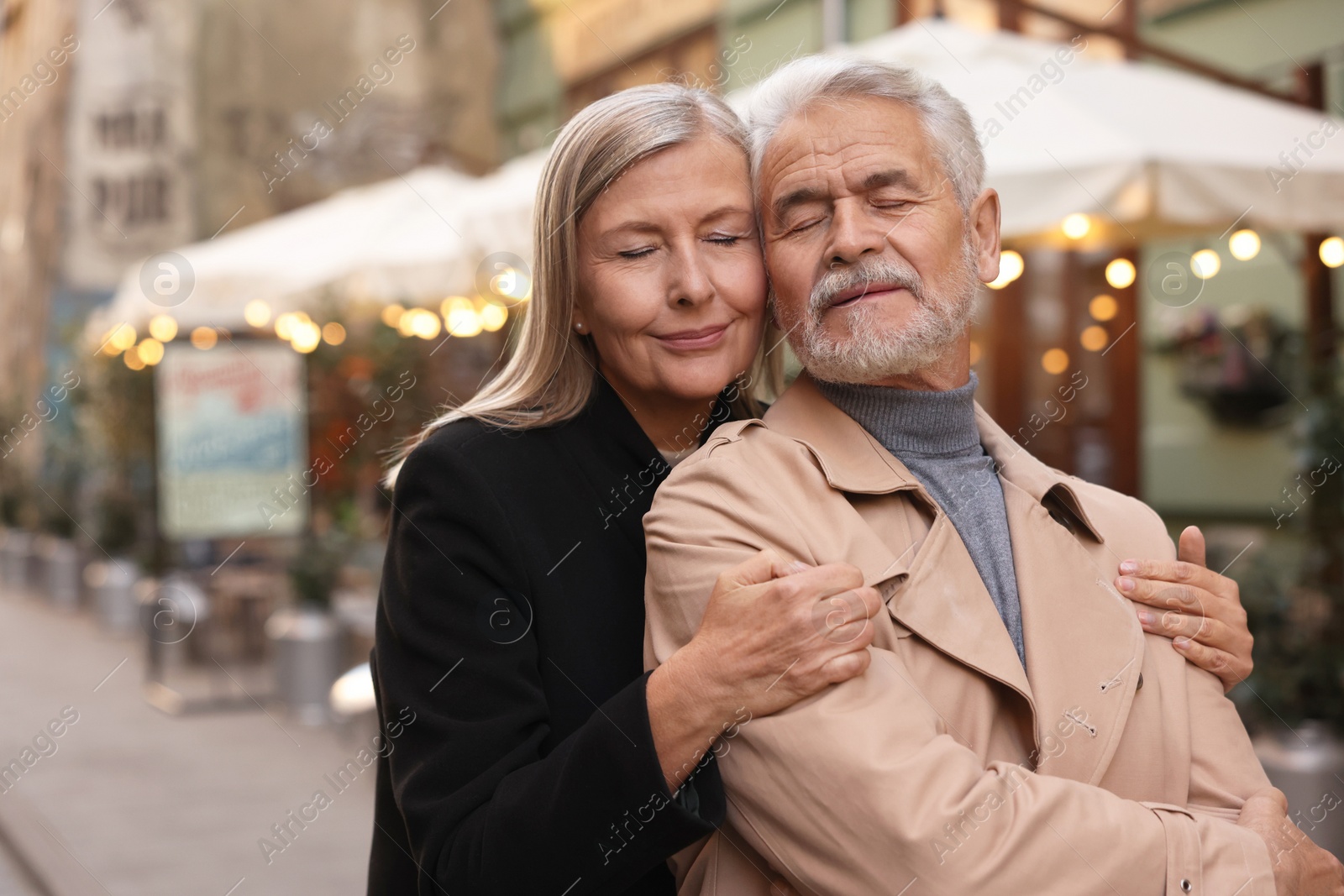 Photo of Portrait of affectionate senior couple on city street, space for text
