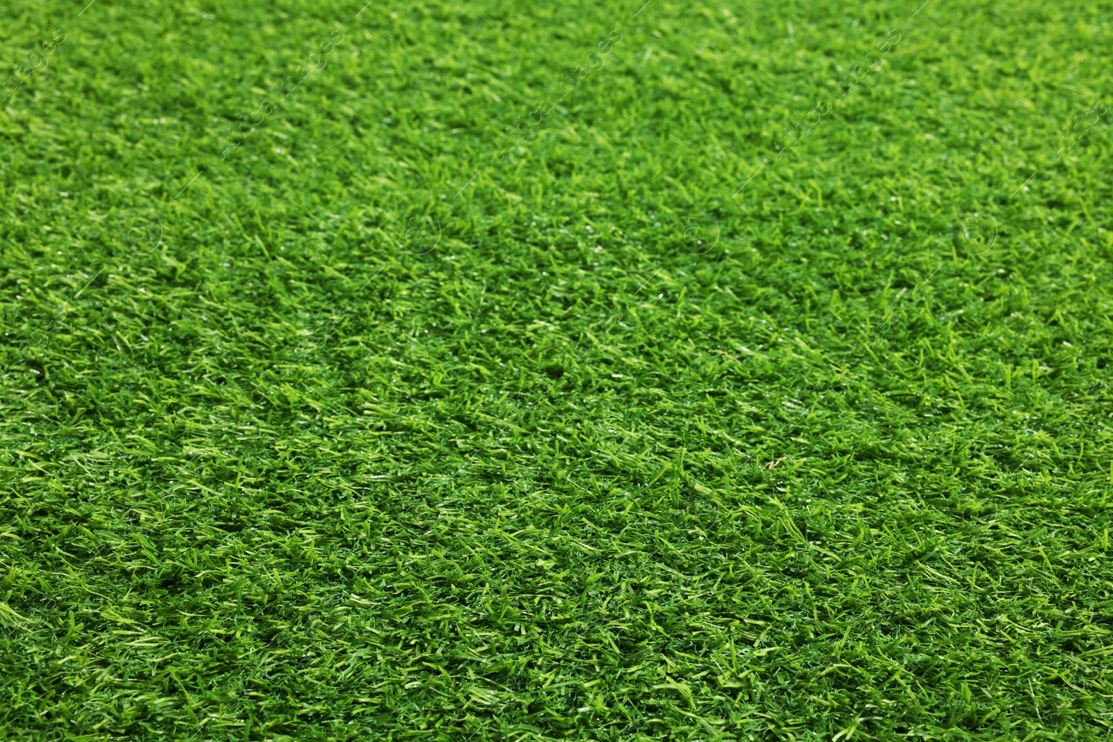 Photo of Green artificial grass as background, closeup view