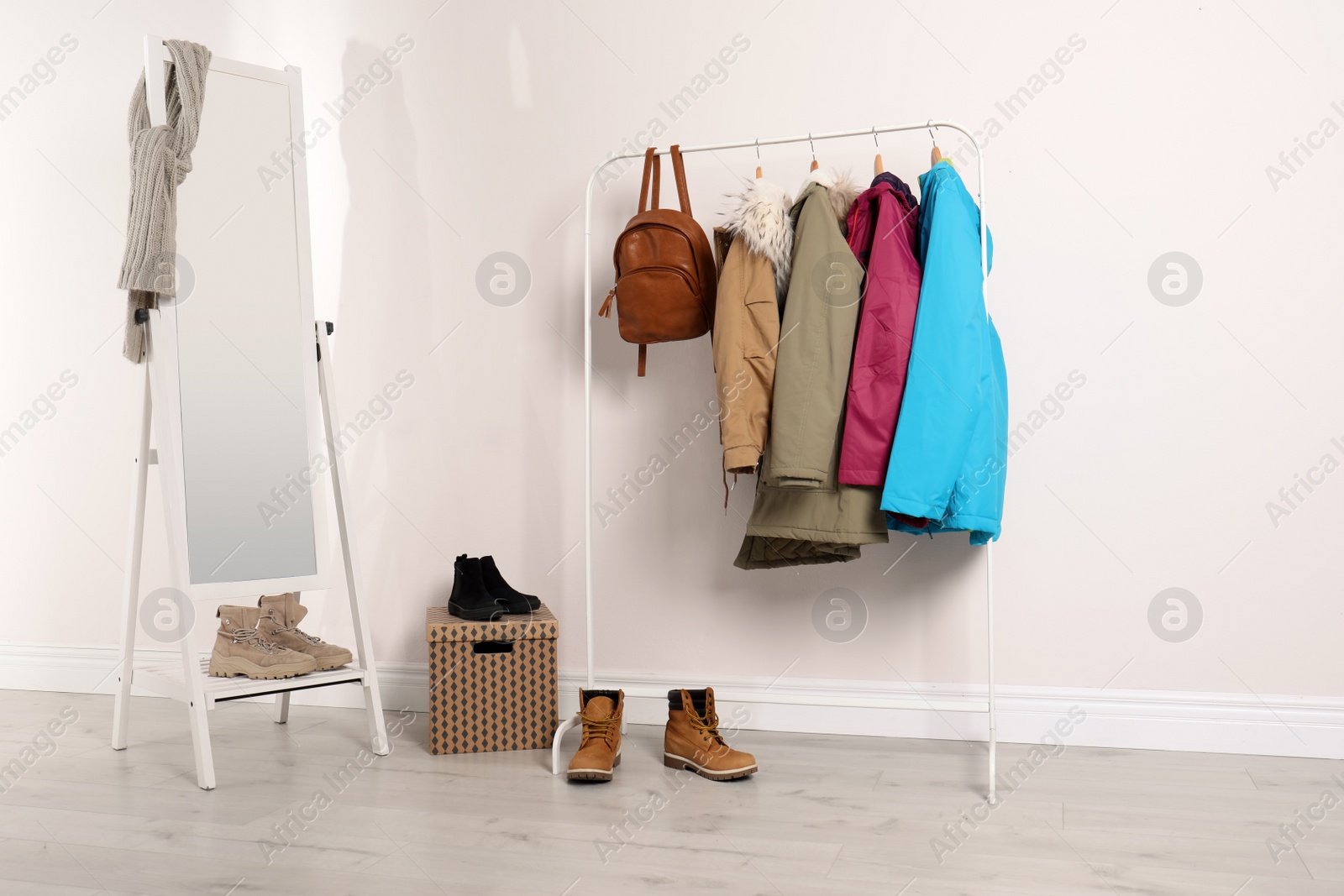 Photo of Modern hallway interior with mirror and clothes on hanger stand