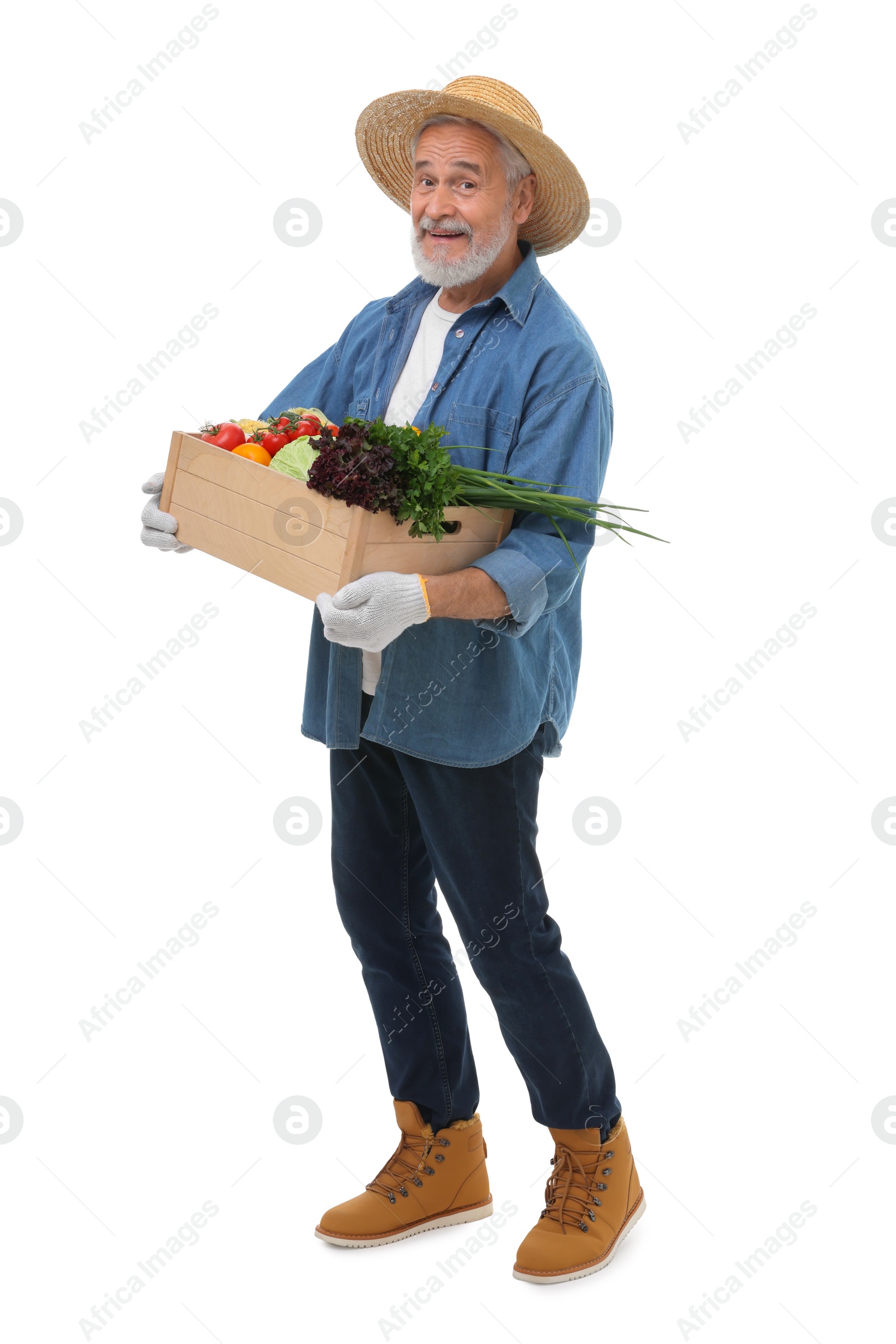 Photo of Harvesting season. Happy farmer holding wooden crate with vegetables on white background