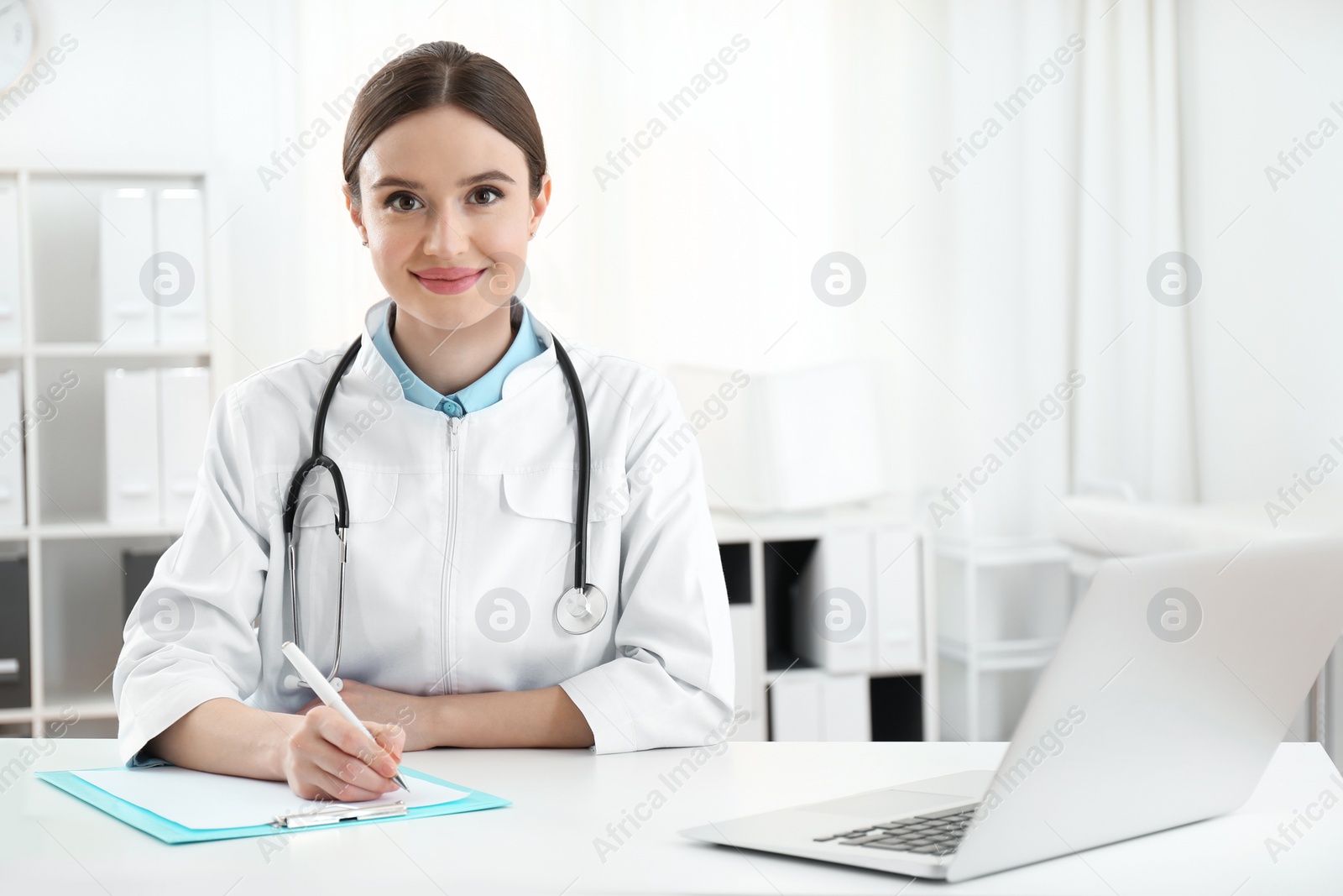 Photo of Portrait of young female doctor in white coat at workplace